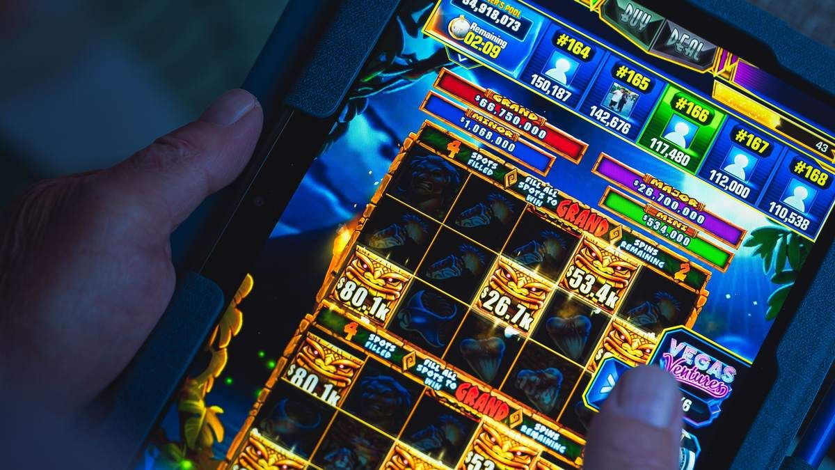 A player tapping an online casino slot game on a tablet