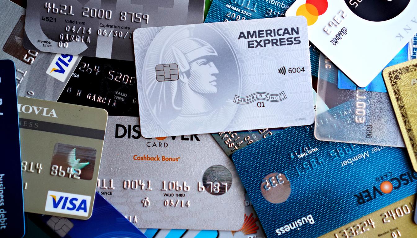 A pile of overlapping credit and debit cards including American Express, Visa and Mastercard